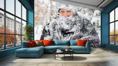 close up portrait of frost man face covered by snowy scarf and hat outdoor, winter concept f Wall mural