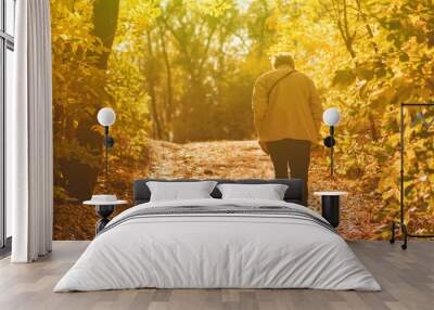 lonely senior man walking in the autumn forest with fallen leaves, sadness concept Wall mural