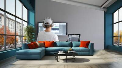 male producer in headphones doing music at home using computer Wall mural