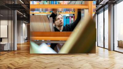 portrait of man through the books in library b Wall mural