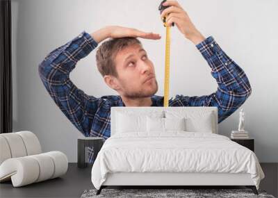 simple adult teenager male person with a roll tape measure the height against the wall Wall mural