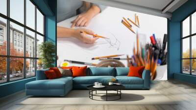 young female artist drawing cartoon on a paper with pencil Wall mural