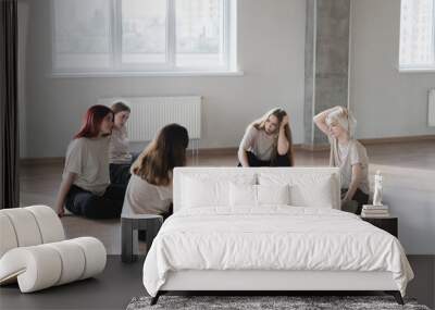 young female dancers tired and exhausted after practice session in the class Wall mural