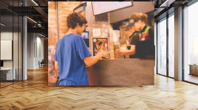 young man received his food package order in fastfood restaurant Wall mural