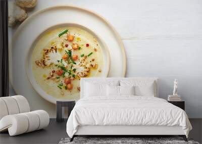 Vegan cauliflower soup on white background. Healthy vegan cauliflower soup served in bowl on white table. Wall mural