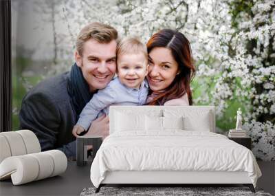 Happy young family walking in a city park Wall mural