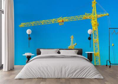 two tops of construction cranes on sky Wall mural