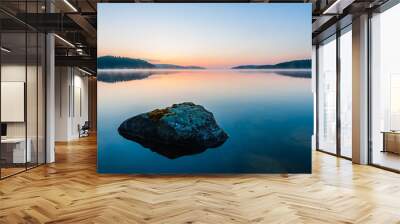 Stone lying in still lake at sunrise. Åtvidaberg, Sweden. Wall mural