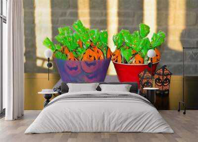 Two bowls filled with pre-packaged bags of candy along with a big black plastic spider and black and orange lanterns wait for trick or treaters on Halloween. Wall mural