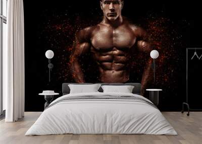 Brutal strong muscular bodybuilder athlete man pumping up muscles on black background. Workout bodybuilding concept. Copy space for sport nutrition ads. Wall mural