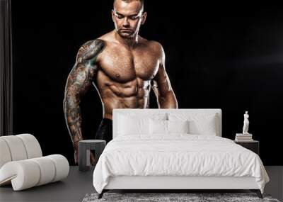 handsome fit man posing wearing in jeans with tattoo. sport and fashion concept isolated on black ba Wall mural