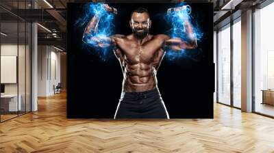 Strong and fit man bodybuilder. Sporty muscular guy with dumbbells. Spot and fitness motivation. Energy and power. Wall mural