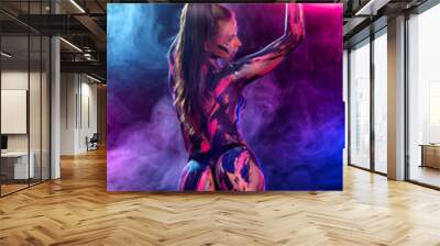 Young woman painted different colors. Inspired dance to music. Body art colorful. An amazing woman with art fashion makeup. Wall mural