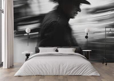 The image captures a man in a black suit and hat walking away from the camera, with a blurry black-and-white effect that conveys a sense of motion and mystery. Wall mural