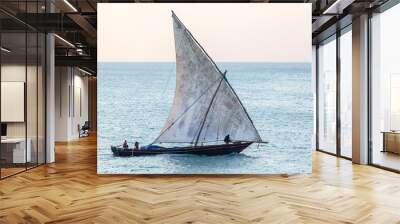 traditional dhow sailing boat sleak and fast silhouetted against the blue ocean and sky Wall mural