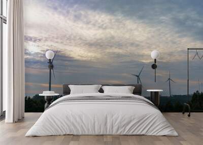 wind turbines generating green renewable energy viewed against a cloudy sky at dusk or dawn Wall mural