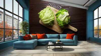 Iceberg lettuce on cutting board on wooden table background. Whole heads of fresh crisphead lettuce Wall mural