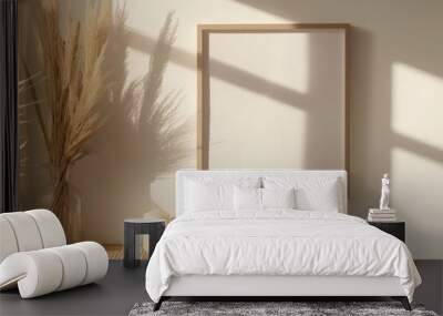 Photo frame mockup in a living room with soft light casting shadows on a white wall, adorned with wooden decor and dry grass Wall mural