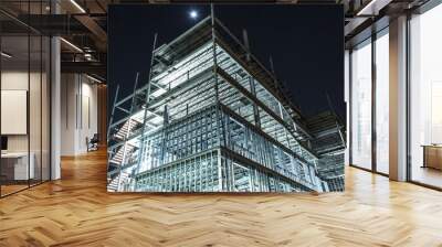 metal framed multi floor building under construction illuminated at night Wall mural