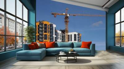 Orange tower crane near a house under construction with orange walls Wall mural