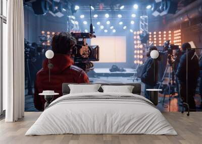 Group of cameramen and technicians are working on a tv show set, surrounded by professional equipment. The stage is lit with warm lights Wall mural