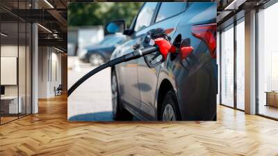 Handle of the filling gun in car gasoline tank in focus, background blurred Wall mural