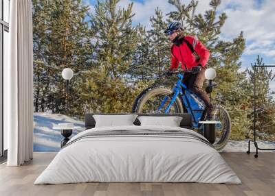 Man riding a mountain bike with big fat tires and helmet on a snow. Fat bike. Wall mural