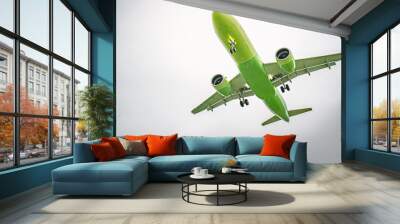 Green airplane flying in a cloudy sky Wall mural