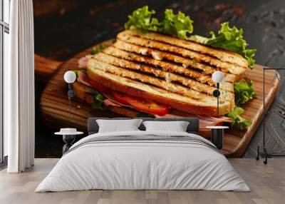 Delicious grilled toast with smoked ham, cheese, tomato, and lettuce on wooden board Wall mural