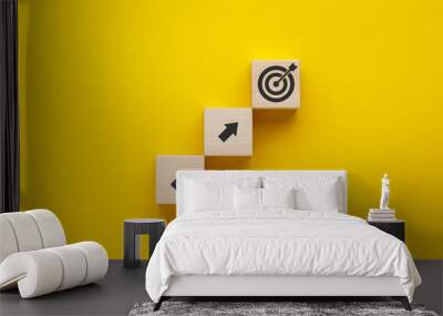 Wooden cubes with arrows and target icons on yellow background. Business development strategy, advancement and goal concept. Wall mural