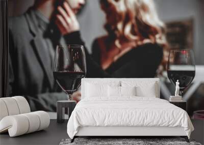 beautiful young couple with glasses of red wine in luxury restaurant Wall mural