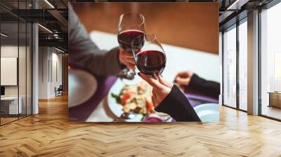 beautiful young couple with glasses of red wine in luxury restaurant Wall mural