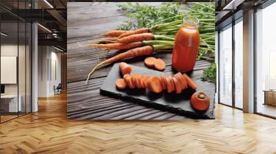 Closeup view at fresh organic vegetarian carrot juice in bottle on wooden kitchen table Wall mural