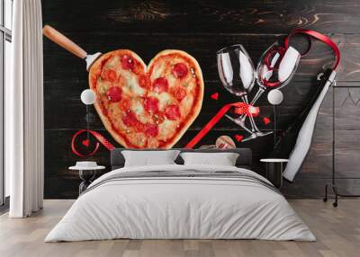 a festive dinner of pizza in the shape of a heart and a bottle of wine. Wall mural