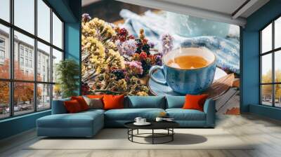 autumn warming tea on a wooden table with autumn tree leaves lying nearby Wall mural