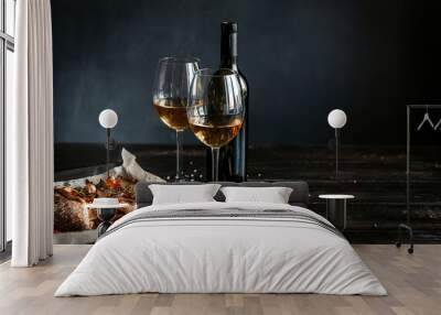 dinner concept for two. two glasses of white wine, baked fish. Wall mural