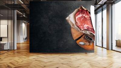 fresh raw marbled beef steak with ingredients rosemary thyme cherry tomatoes pepper salt on a wooden table with a meat ax Wall mural