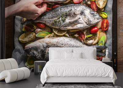 mother cooks dinner for the whole family, bakes dorado fish Wall mural