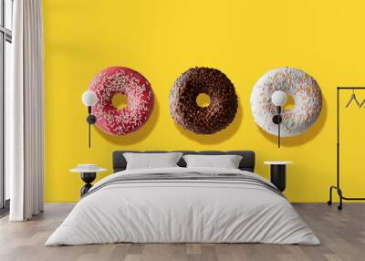 three different donuts on a yellow background Wall mural