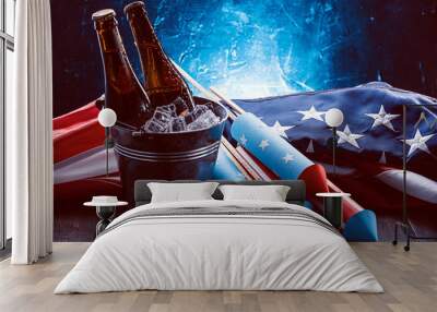 two bottles of beer in an ice bucket with the american flag lying nearby and rockets for fireworks.  Wall mural