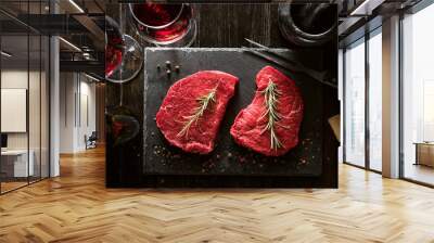 two pieces of fresh meat prepared for frying and wine with glasses on a wooden table Wall mural