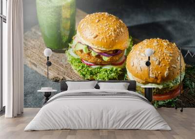 vegetarian, vegan burger with whole wheat buns, tomatoes, onions, vegan mayonnaise and spinach on a fresh bun with flaxseed and sesame seeds, surrounded by spinach leaves. Wall mural