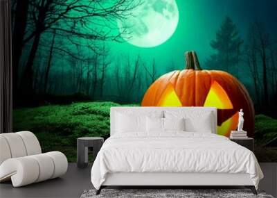 A Halloween carved pumpkin jack-o-lantern with a glowing, eerie smile, on a hunted green moon, forest at night Wall mural