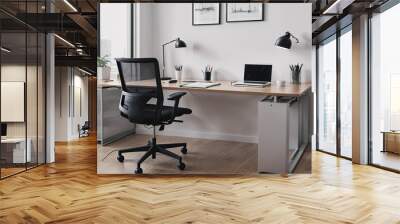 A black office chair sits in front of a desk with a laptop, a keyboard Wall mural