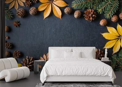 A dark background is framed by fall leaves, pine branches, and pine cones Wall mural