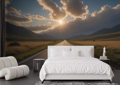 A long, straight road winds through a mountain valley, with the sun shining through the clouds Wall mural