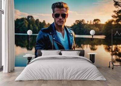 A man in a leather jacket stands by a lake at sunset Wall mural