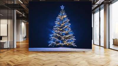 A snowy Christmas tree is lit up with blue lights against a dark night sky Wall mural