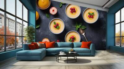 Four bowls of creamy peach dessert topped with raspberries and mint leaves sit on a dark countertop Wall mural