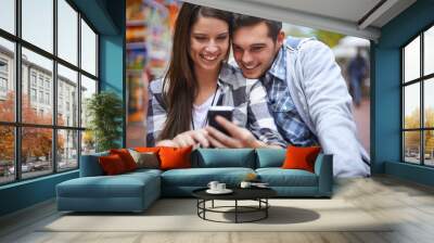 City, smile and couple with a smartphone internet and social media with texting, message and meme. New York, man or woman with a cellphone, mobile user and digital app with network, joy or happiness Wall mural